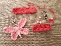 two crocheted items are laying on the floor with key chains attached to them