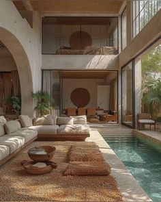 a living room filled with lots of furniture next to a swimming pool in front of a tall building