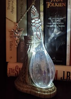 a glass bottle sitting on top of a wooden table next to books and a chain