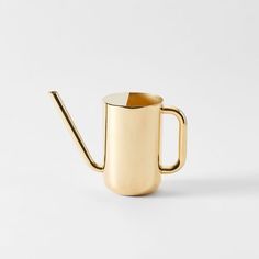 a gold colored watering can with a black handle