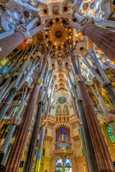 the inside of a cathedral with many columns and stained glass windows