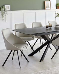 a dining room table with white chairs around it