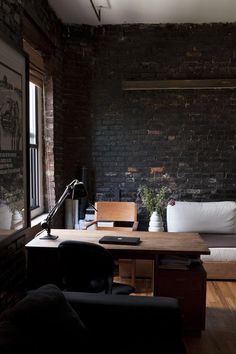 a living room filled with furniture next to a brick wall