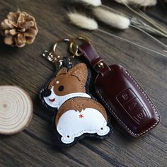 a keychain with a dog on it sitting next to a piece of wood