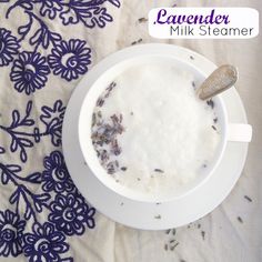 a bowl of oatmeal is sitting on a tablecloth with purple flowers