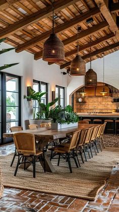 a dining room table with chairs and plants in the center is surrounded by wooden beams