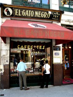 two people standing in front of a cafe