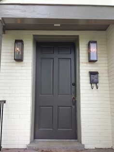 the front door of a house with two lights on it