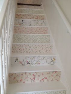 the stairs are decorated with floral wallpapers and decorative hand painted stair treads