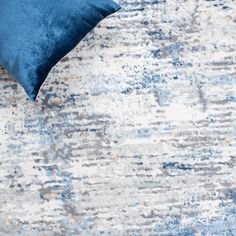 a blue and white rug with a pillow on it