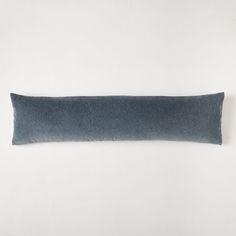 a blue rectangular pillow sitting on top of a white wall