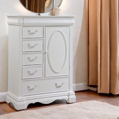 a white dresser with a mirror on top of it next to a rug and window