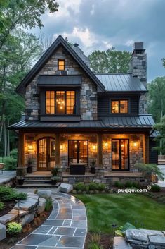 a large house with lots of windows and lights on it's front porch, in the evening