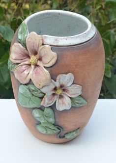 a ceramic vase with flowers painted on it