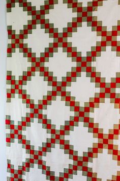 a large red and white quilt hanging on the wall