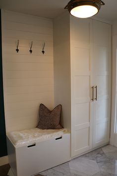 a room with some white cabinets and drawers