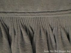 closeup of the pleaed skirt on a woman's dress that is worn by someone