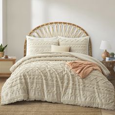 a bed with white comforter and pillows in a room