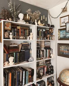 a bookshelf filled with lots of books next to a wall covered in pictures