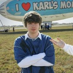 two people standing next to each other in front of a large blue and white airplane