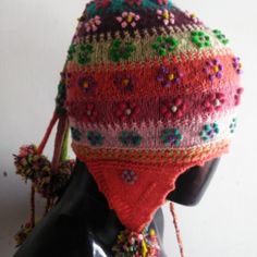 The Chullo Is A Hat With Ears Woven In Wool With Multicolored Drawings, Used In The Andean Regions To Protect Themselves From The Cold. This Chullo Is Originally From The Andean Culture Of Cusco. It Can Also Be Seen In The Pictures. It Has Designs Of Flowers And Pompoms All Around. This Piece Is Handwoven By The Peruvian Artisans Of The Andean Community Of Cusco. Bohemian Knitted Yarn Hats, Bohemian Hand Knitted Hat One Size, Bohemian Hand Knitted Hat, Adjustable Brimmed Bohemian Beanie, Bohemian Adjustable Brimmed Beanie, Bohemian Hand Knitted Brimmed Hat, Bohemian Winter Bonnet, One Size Fits Most, Multicolor Bohemian Beanie Hat, Bohemian Multicolor Beanie