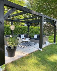 an outdoor living area with couches, tables and a pergolan style gazebo