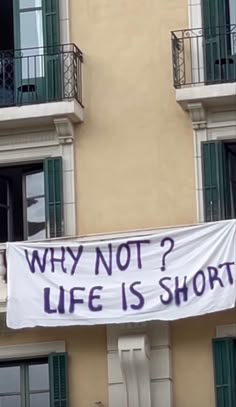 a banner that says why not? life is short on the side of a building