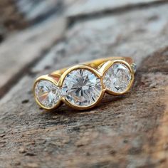 three stone ring sitting on top of a rock