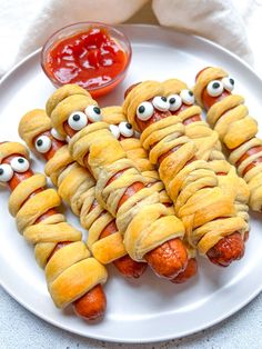 hot dogs wrapped in bread with googly eyes on them and ketchup for eyes