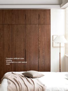 a bedroom with wood paneling and white bedding