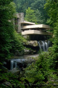 the falling house is surrounded by lush green trees and water flowing from it's sides