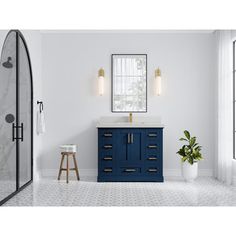 a bathroom with white walls and blue cabinetry next to a large mirror on the wall