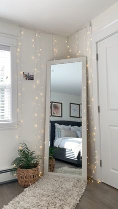 a bedroom with lights on the wall and a large mirror in the middle of the room