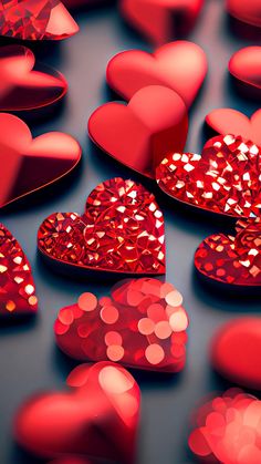 many red hearts are arranged in the shape of heart shaped boxes with glitter on them