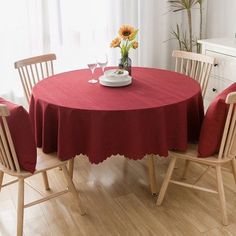 a red table cloth with scalloped edges sits on a wooden dining room table