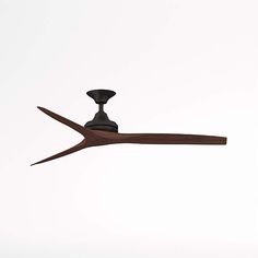 a ceiling fan that is on top of a white wall with a brown wooden blade