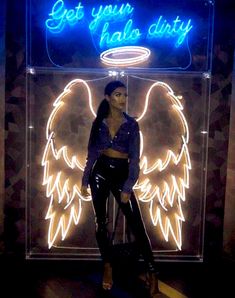 a woman standing in front of a neon sign