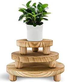 three tiered wooden plant stand holding a potted plant on top of each other