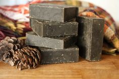 several soap bars stacked on top of each other next to a pine cone and blanket