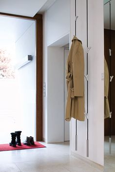 a coat hanging on the wall next to a pair of boots