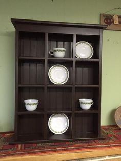 a wooden shelf with plates and bowls on it