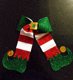 a pair of green and red christmas stockings on top of a black surface with gold buttons