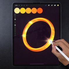 a person using a pen to draw a glowing ring on an ipad screen with the touch pad