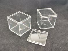 three clear boxes sitting on top of a black surface