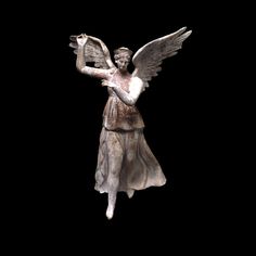 an angel statue holding a bird in its right hand on a black background with copy space