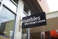 there is a sign that says marbles the brain store