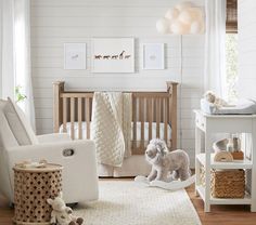 a baby's room with white walls and wooden furniture