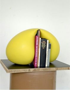 there is a yellow sculpture with books on it