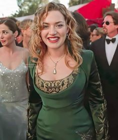 a woman in a green dress smiling at the camera