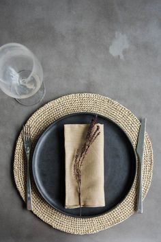 a black plate with a napkin and some silverware